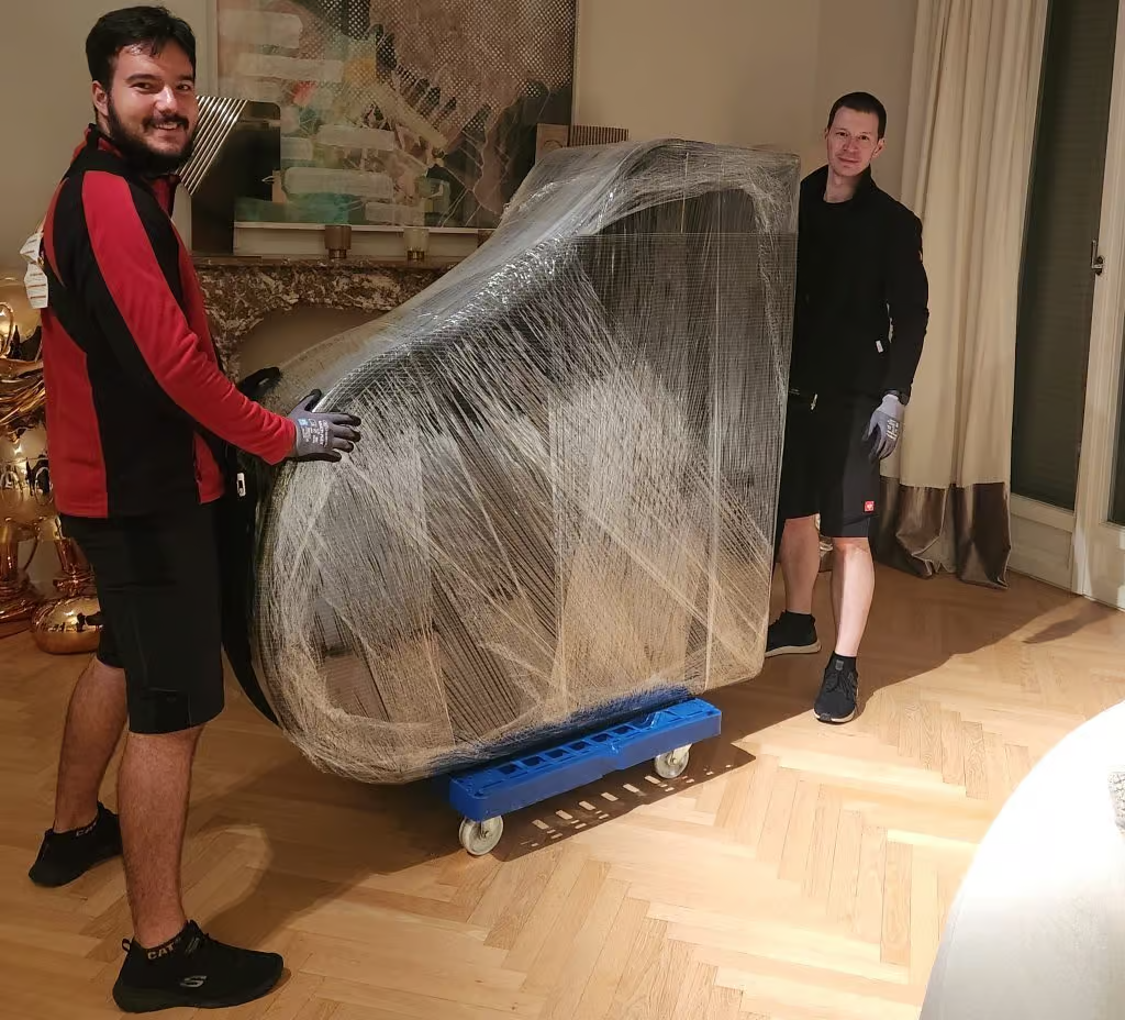 FlexiTrans-Team transportiert ein verpacktes Klavier