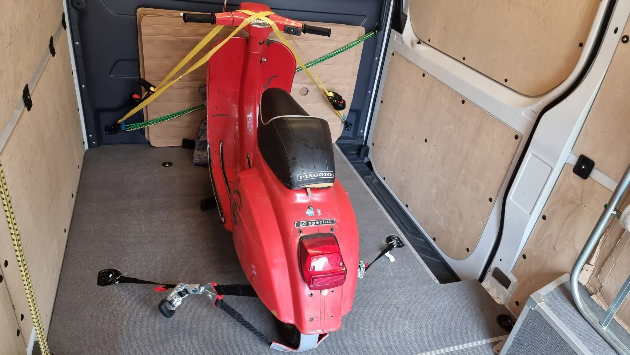 Red scooter secured in a van